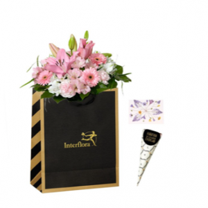 Presentpåse med blombukett i rosa samt en strut choklad. Presentsetet hittar du i Interfloras webshop.
