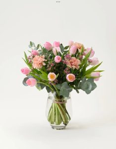 Interfloras månadsbukett för januari. Den innehåller rosa tulpaner, vaxblommor, aprikosa nejlikor, gröna eucalyptusblad och pistage. Grymt fin!