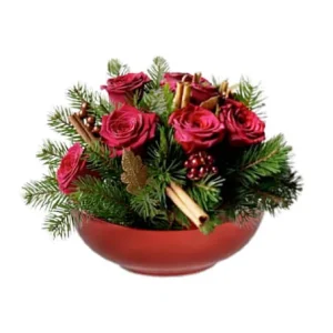 På bilden: Rund liten julgrupp med röda rosor, gröna grankvistar, kanelstänger.